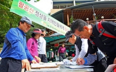 대구등산학교 총동창회 회원들이 20일 팔공산 탑골 등산로 입구에서 '팔공산 정상을 지역민들에게 돌려주세요'라는 현수막을 내걸고 비로봉 정상 개방을 위한 서명운동을 시작했다.